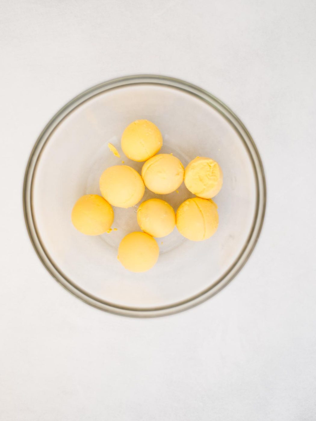 cooked egg yolks added to a mixing bowl.