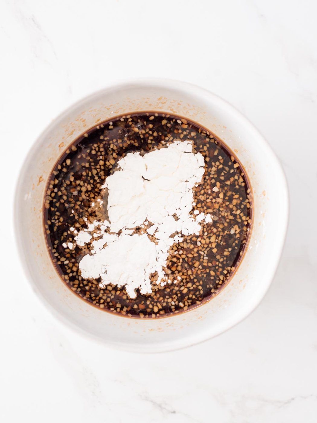 corn starch added to soy sauce in a bowl