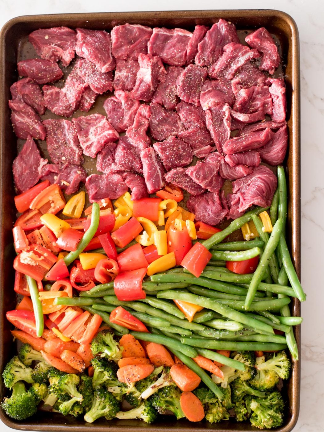 broccoli, carrots, green beans, bell pepper, and beef on a sheet pan