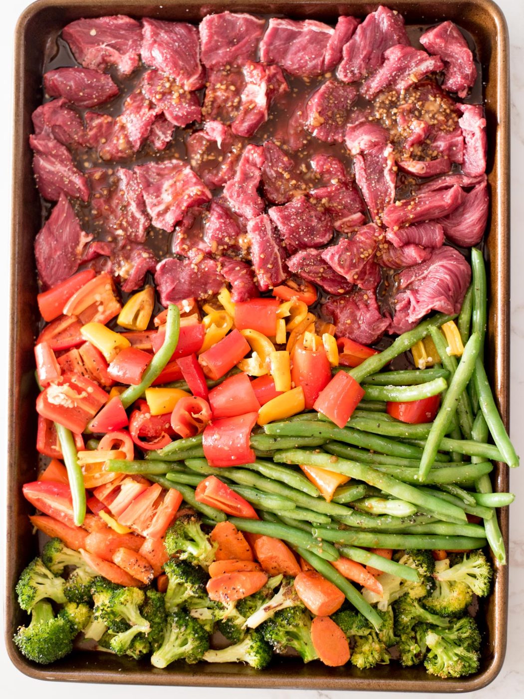 teriyaki sauce poured over all items on a sheet pan