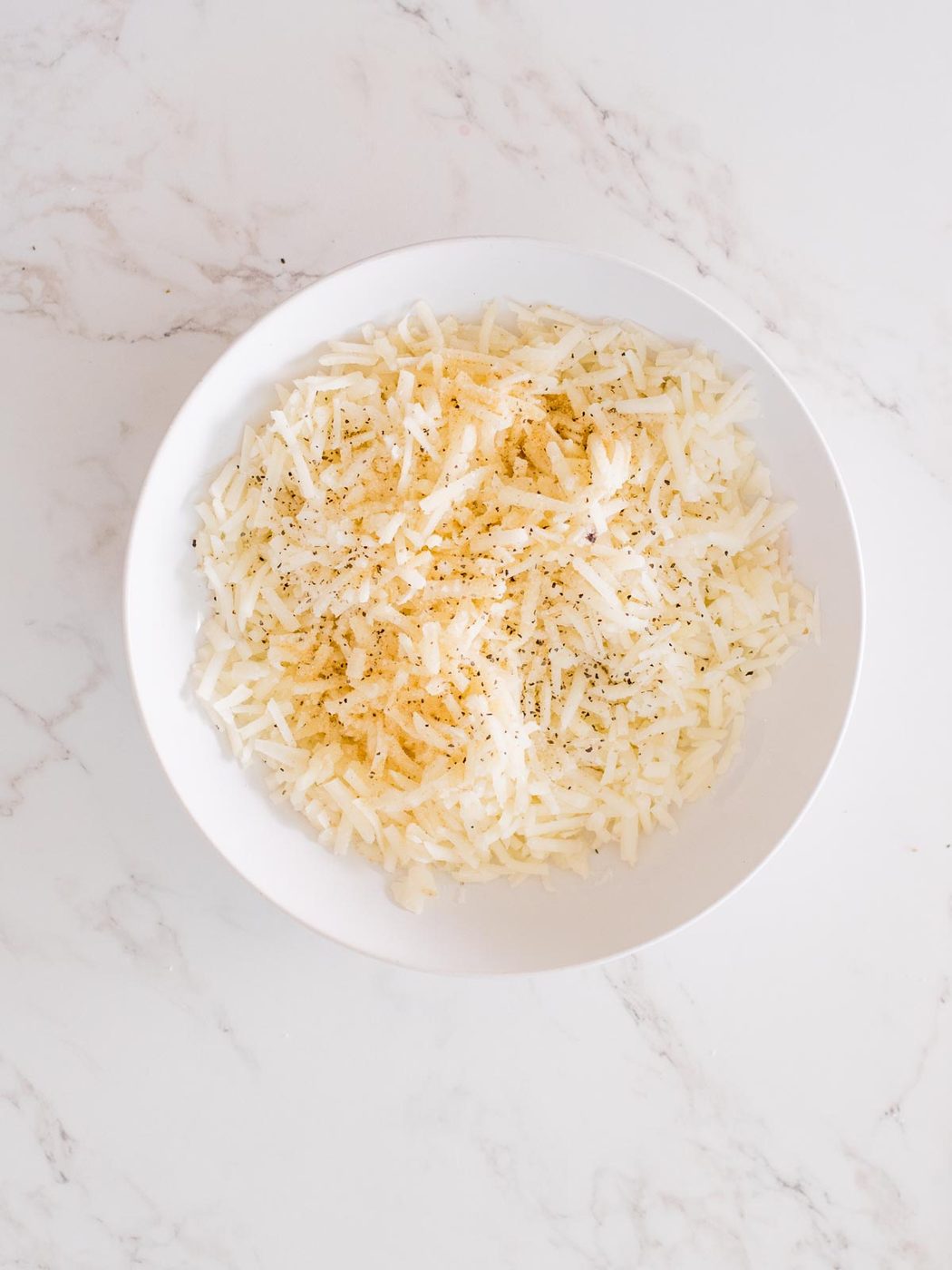 seasoned hashbrowns in a mixing bowl
