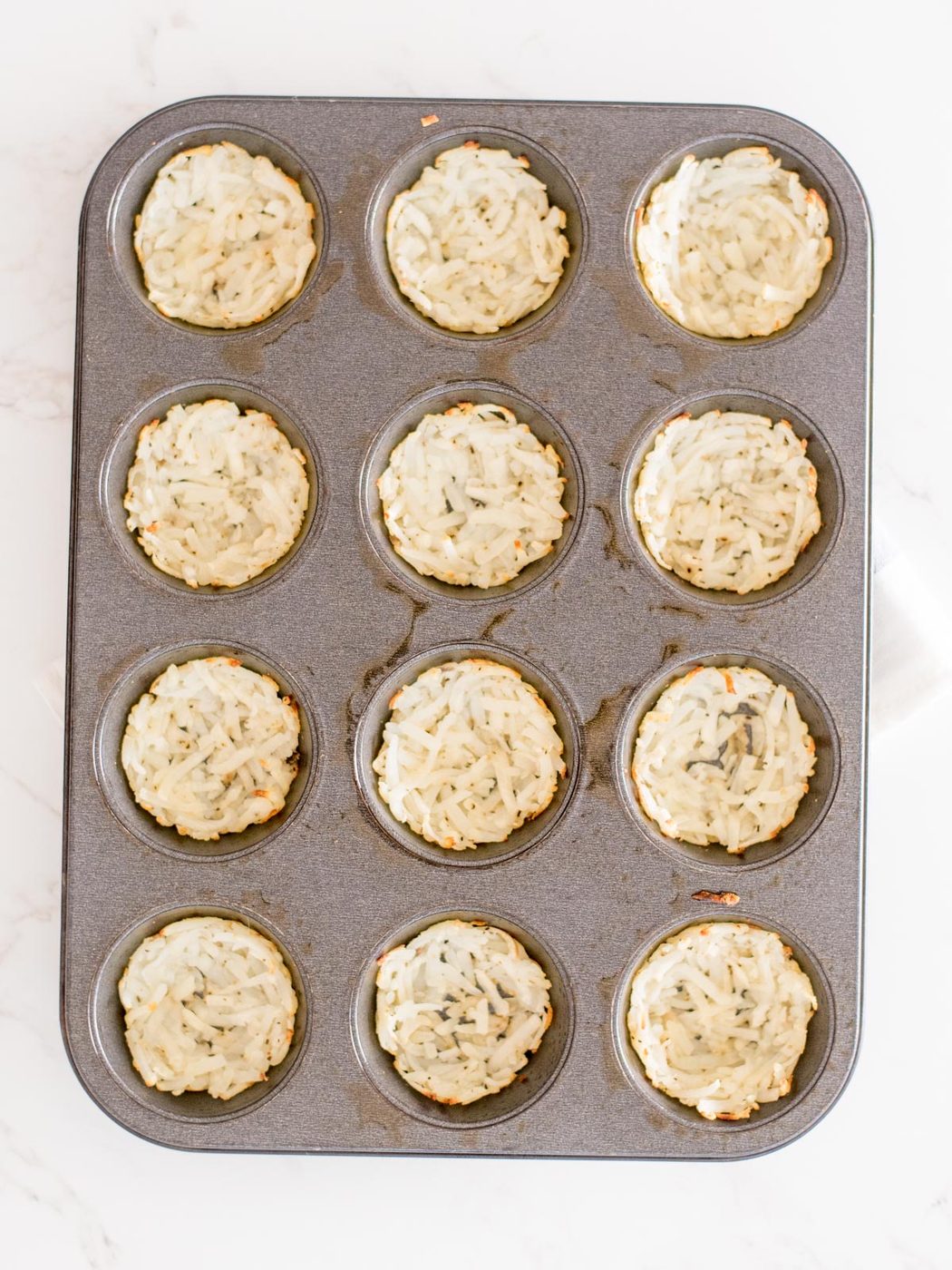 cooked hashbrowns in a muffin tin