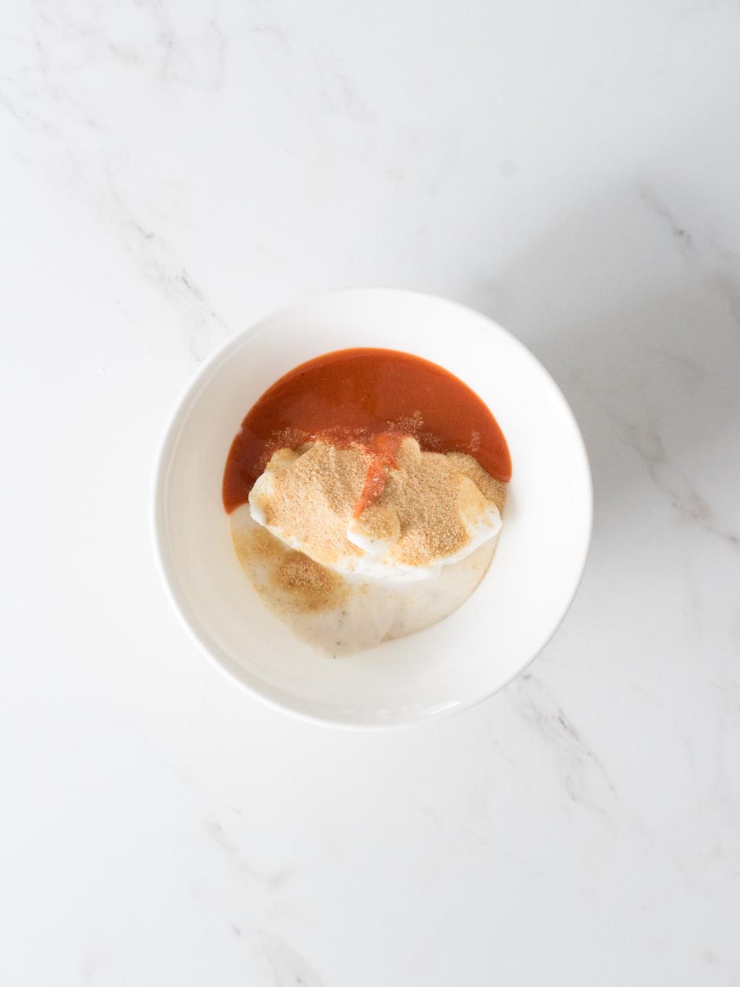 hot sauce, garlic powder, sour cream, and ranch in a bowl