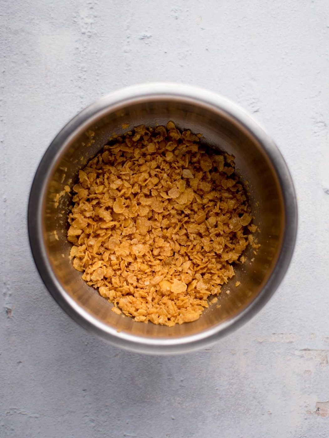 cornflakes and melted butter mixed together in a mixing bowl