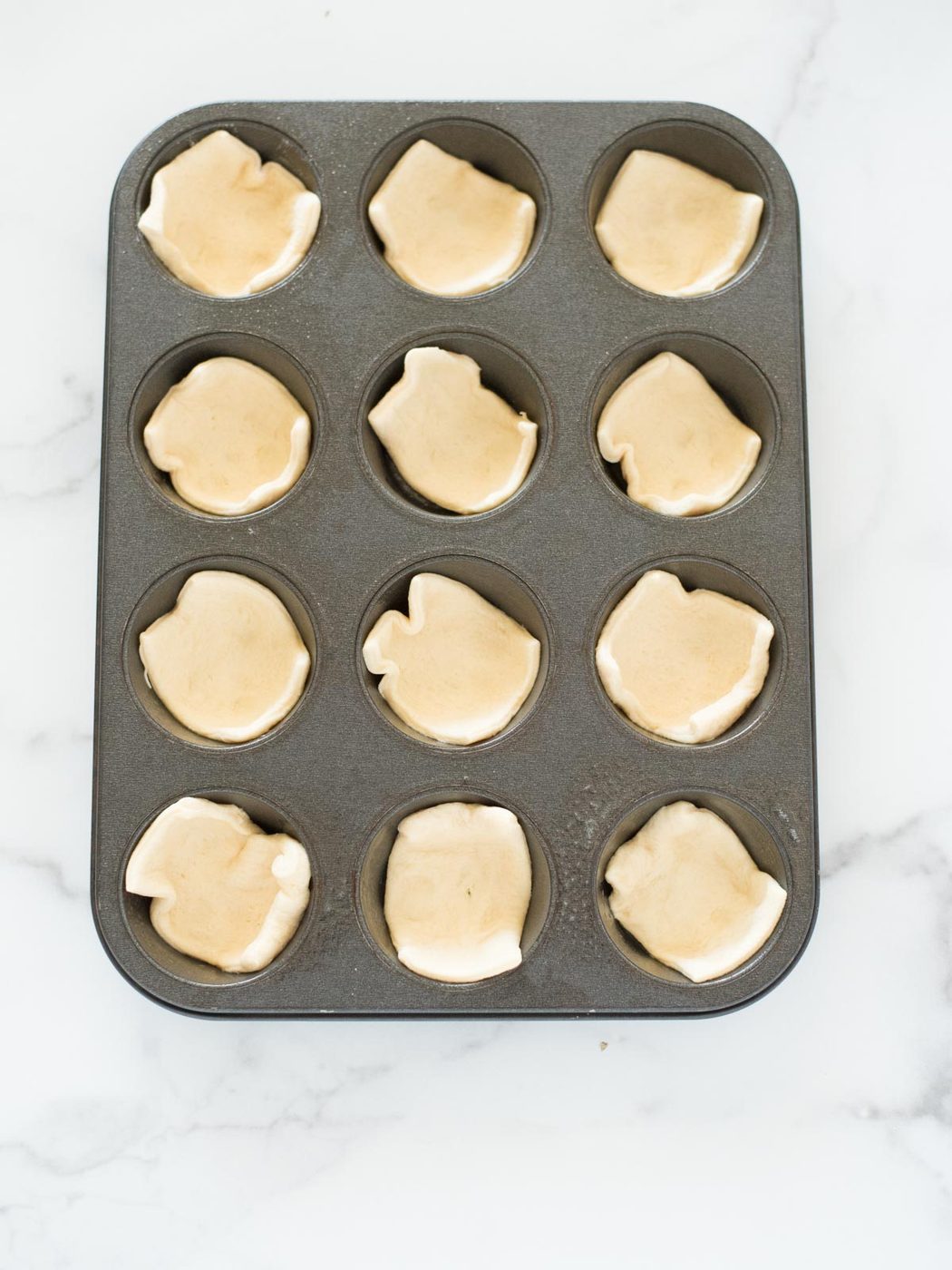 crescent roll dough in a muffin tin