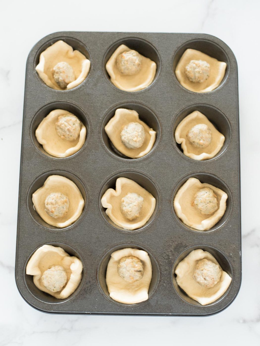 meatballs in crescent dough in a muffin tin