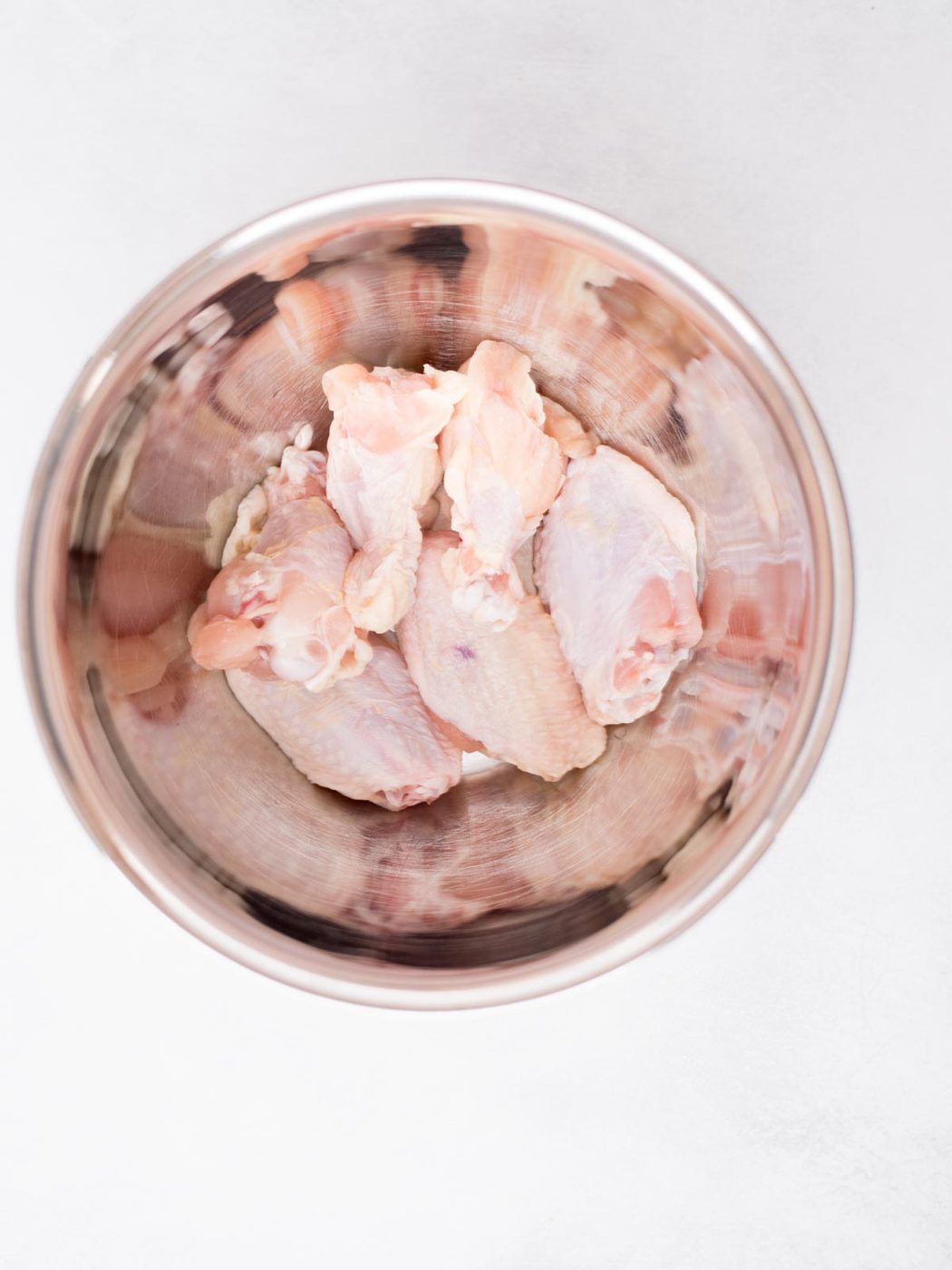 raw wings in a mixing bowl