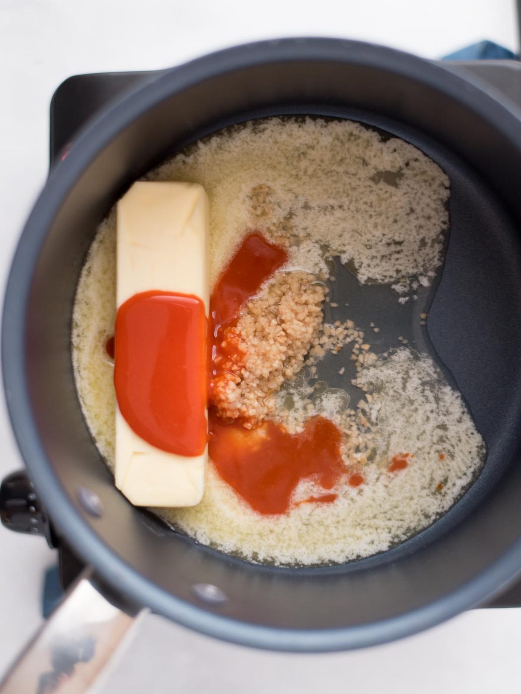 butter, wing sauce, garlic, and lemon juice in a saucepan