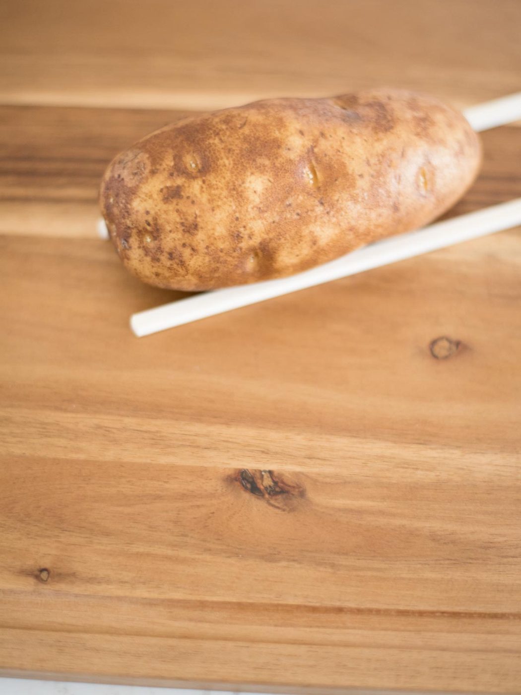 russet potato on chopsticks