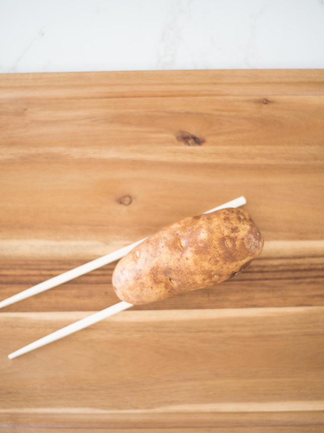 russet potato on chopsticks
