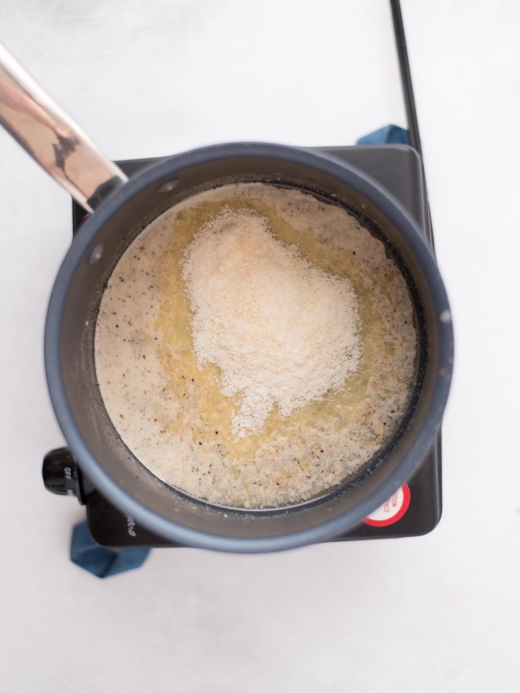 parmesan added to melted butter mixture in a saucepan