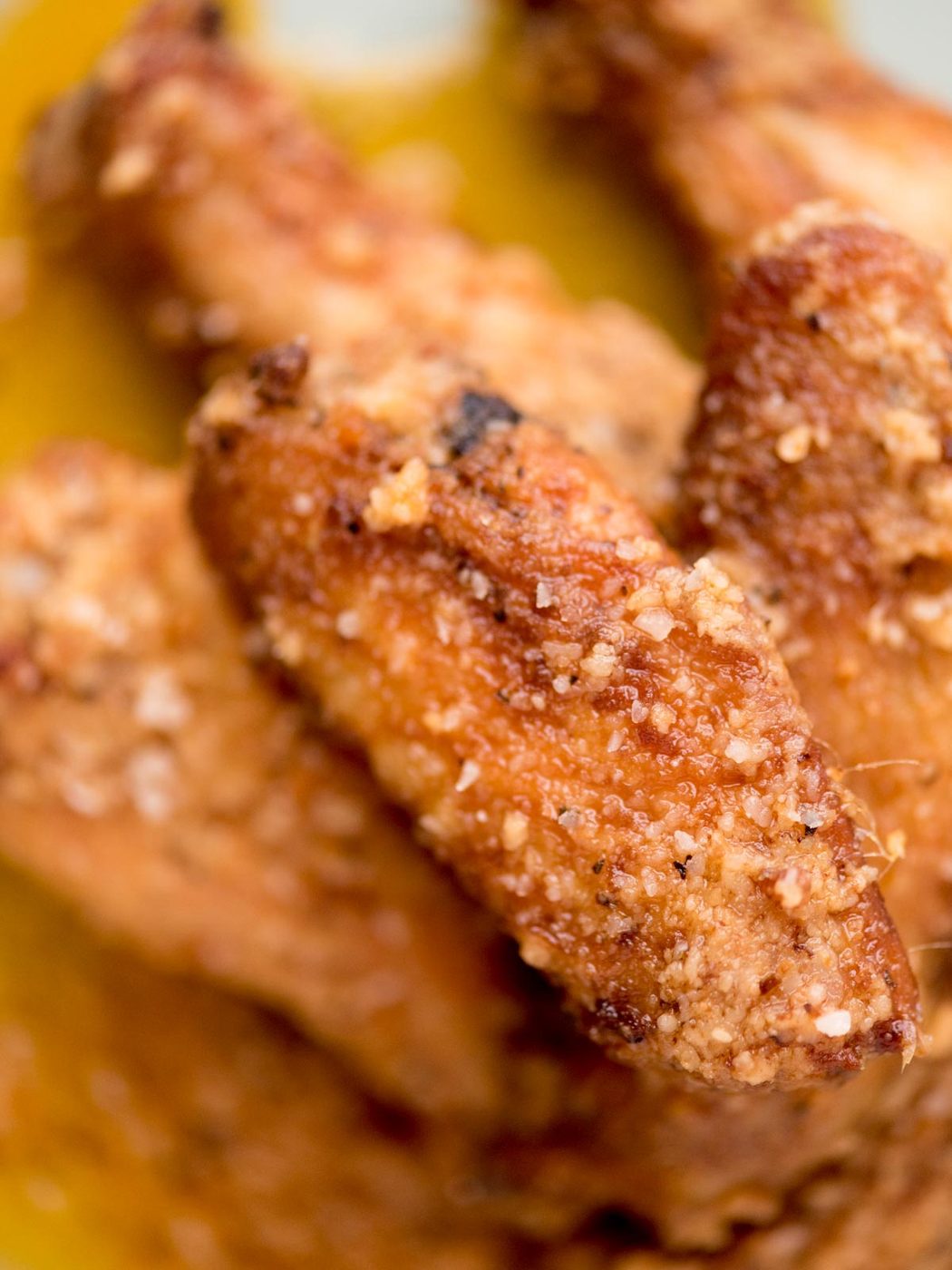 garlic parmesan chicken wings stacked on a light blue plate