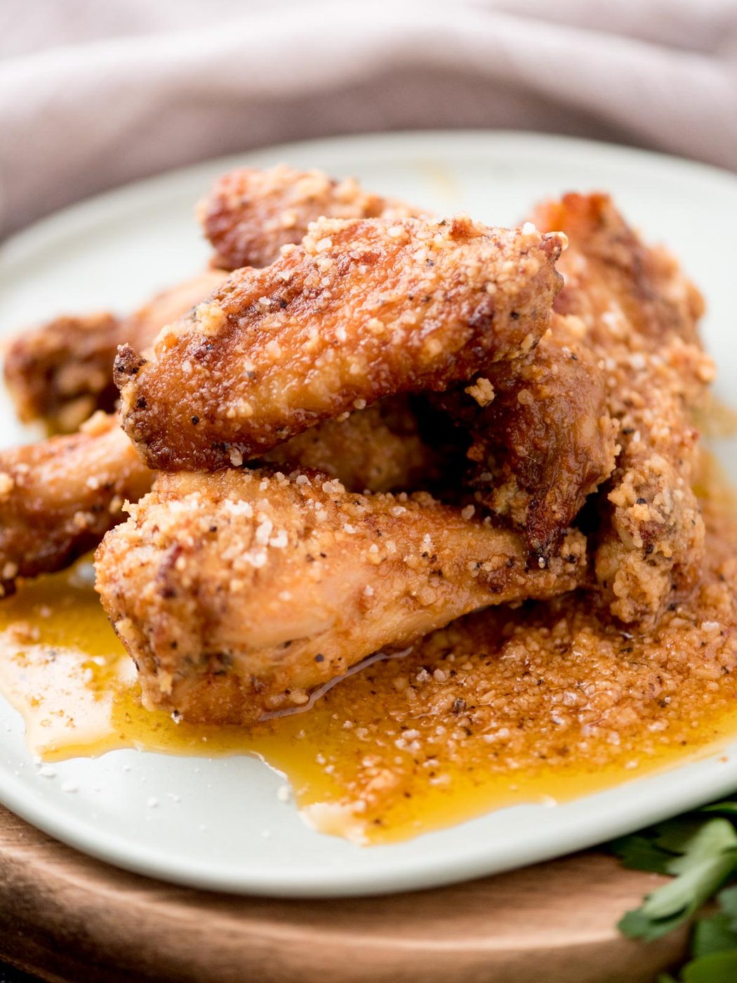 garlic parmesan chicken wings stacked on a light blue plate
