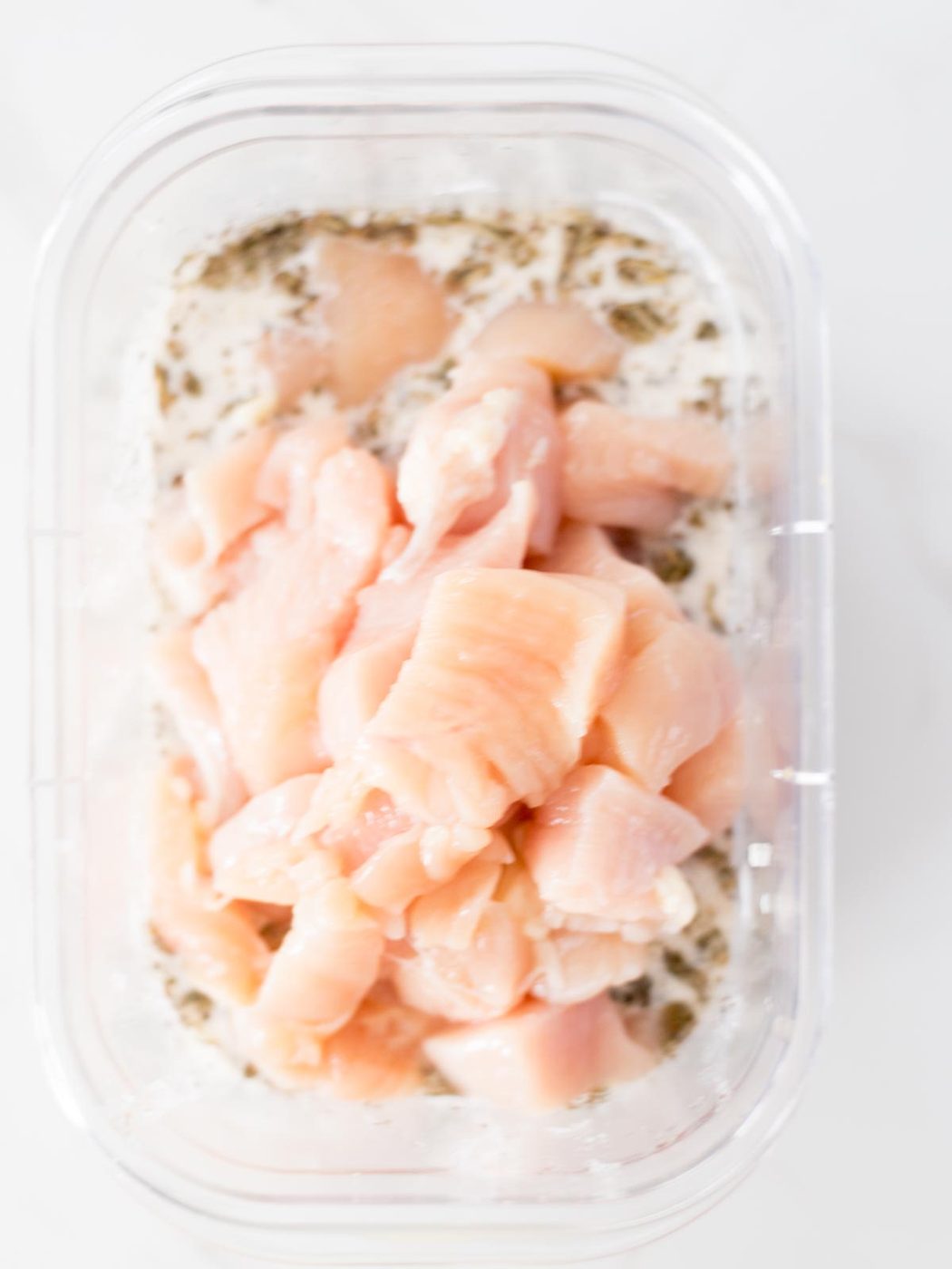 chicken added to marinade in a bowl