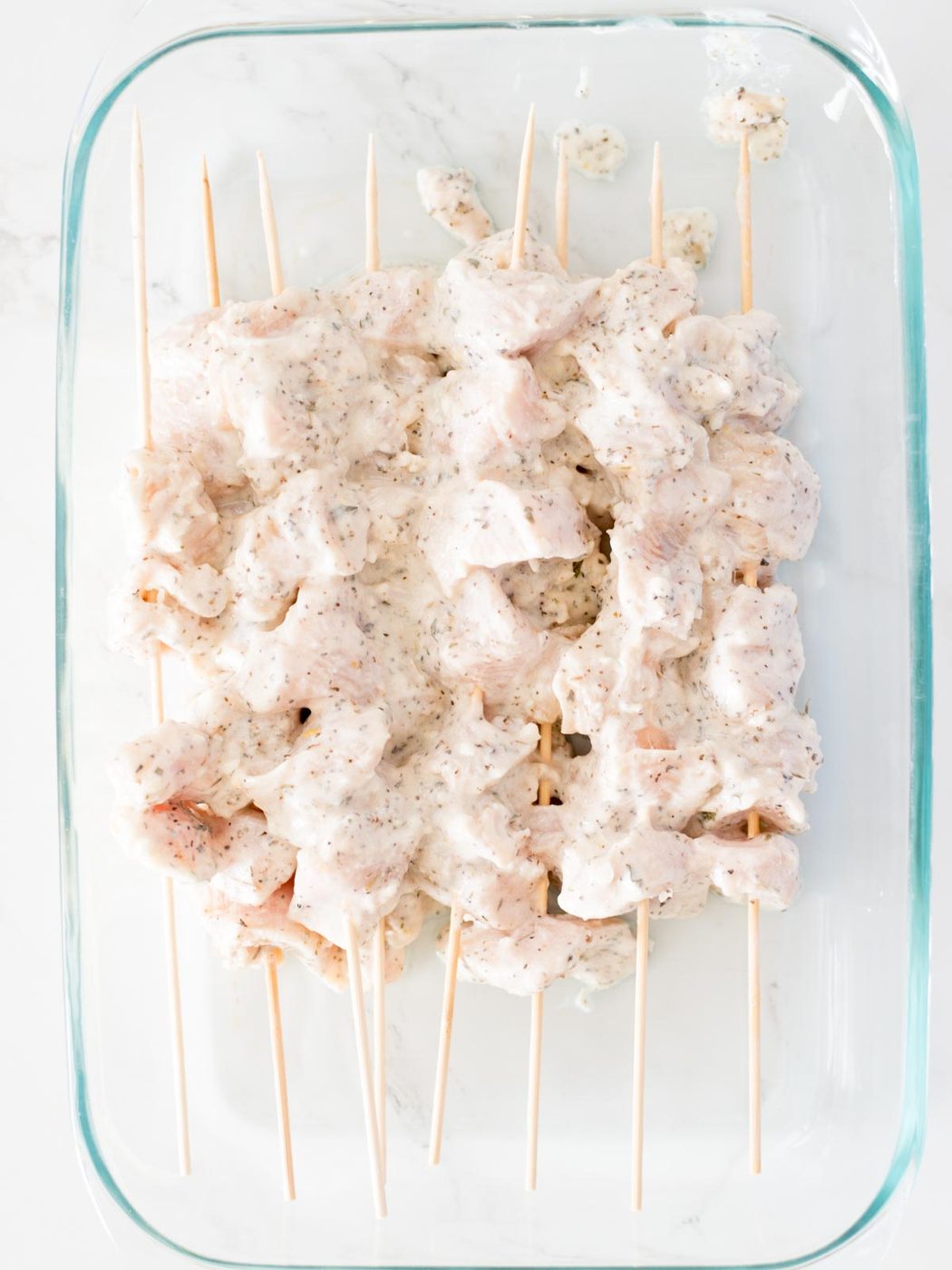 chunks of chicken covered in marinade on skewers