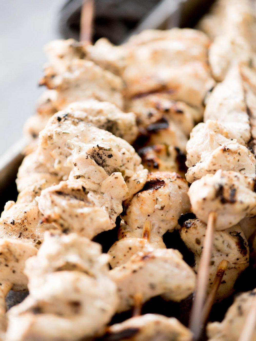 greek grilled chicken skewers stacked together with tzatziki sauce