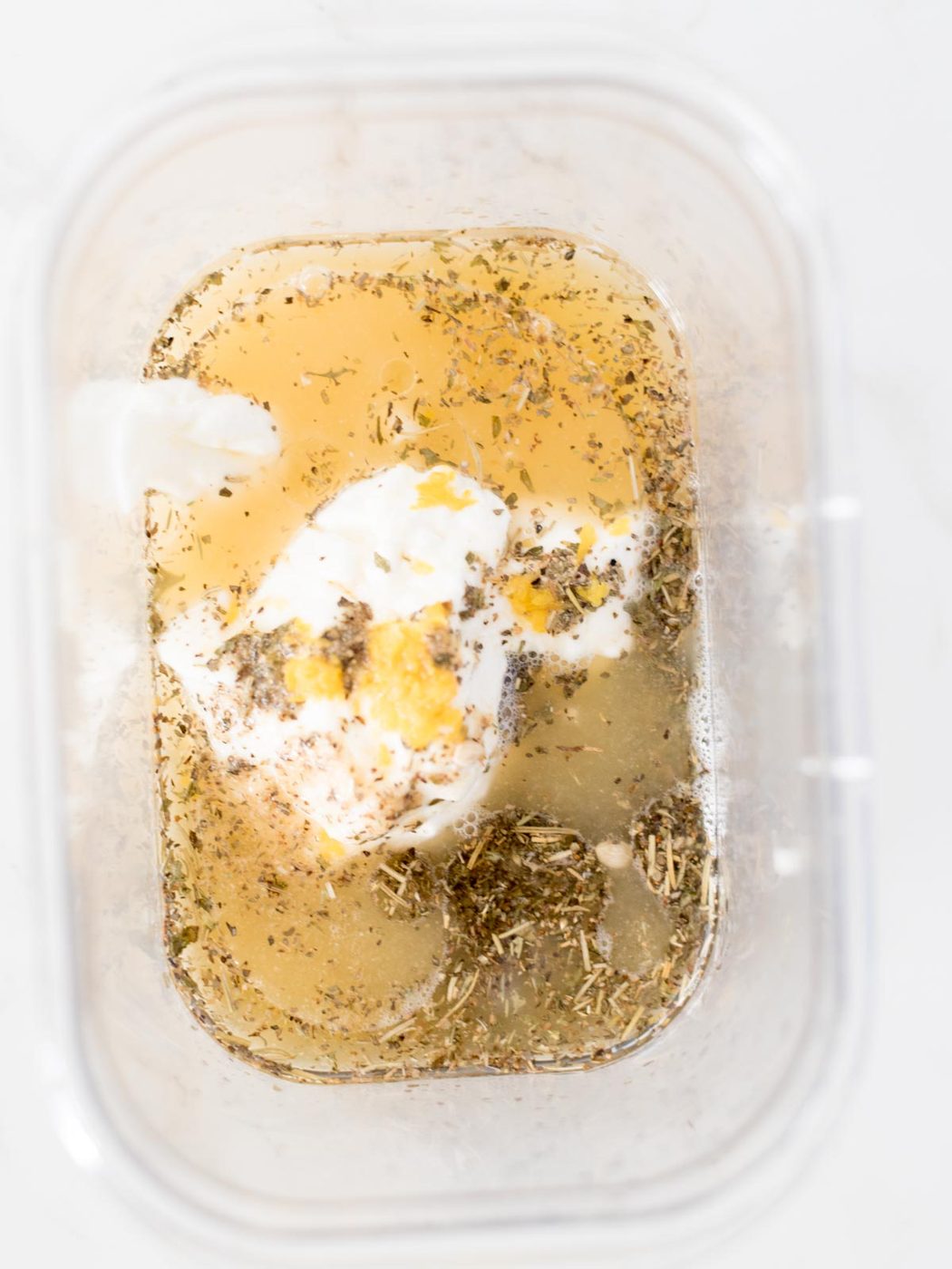 lemon juice, greek seasoning, yogurt, and olive oil in a bowl