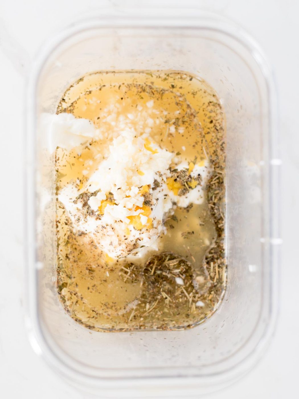 garlic, olive oil, yogurt, lemon juice, and greek seasoning in a bowl