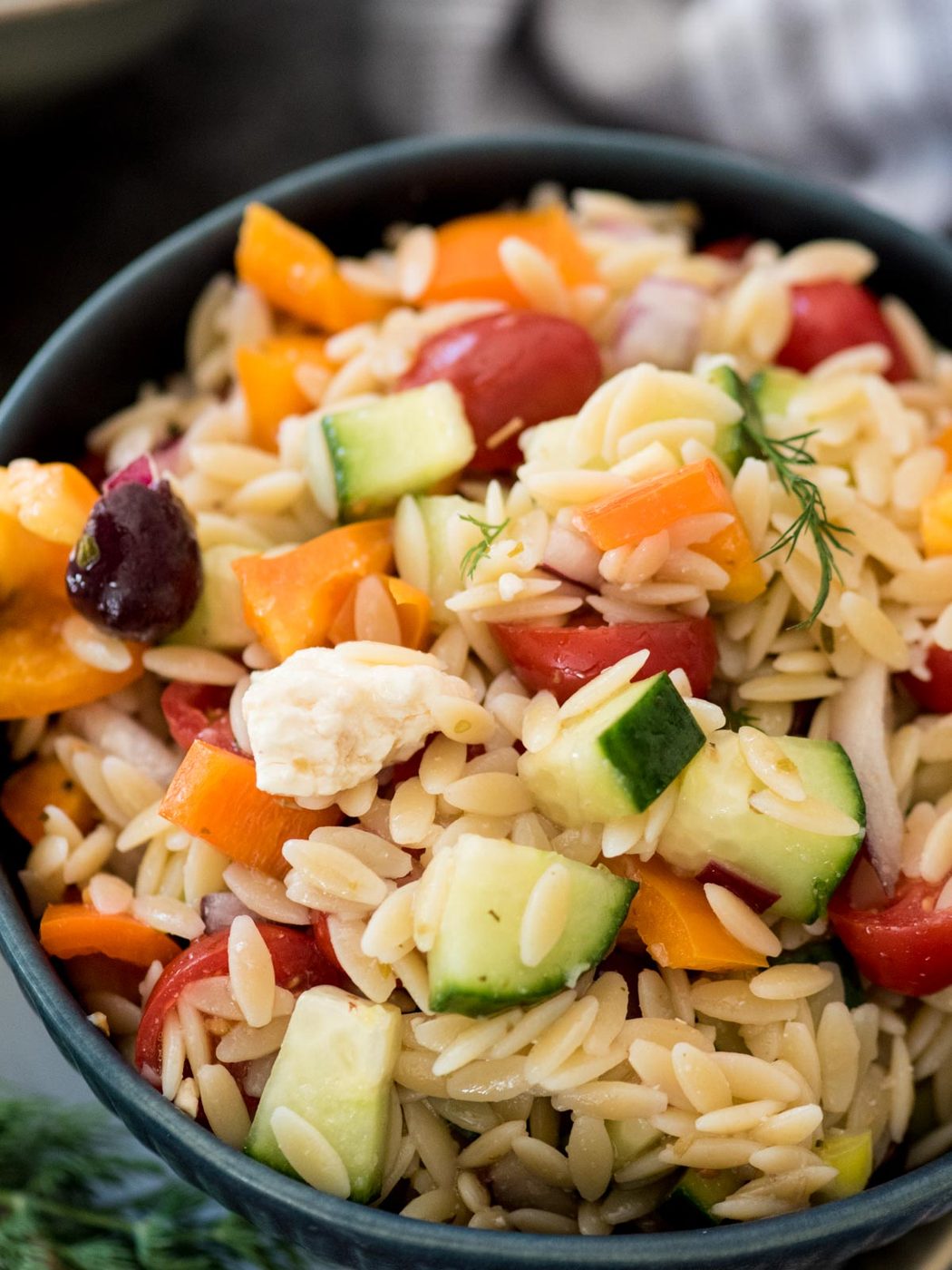 orzo salad in a bowl topped with fresh dill