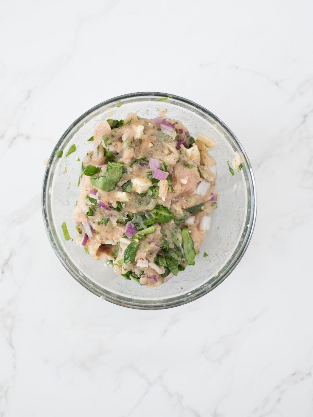greek turkey burger ingredients mixed together in a bowl