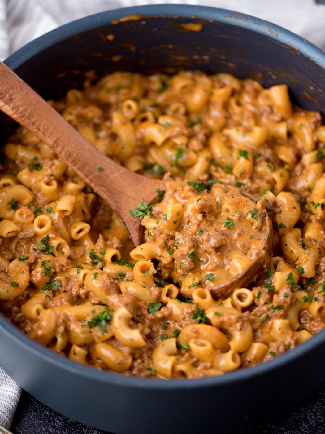 From-scratch hamburger helper in a skillet with a wooden spoon in it.