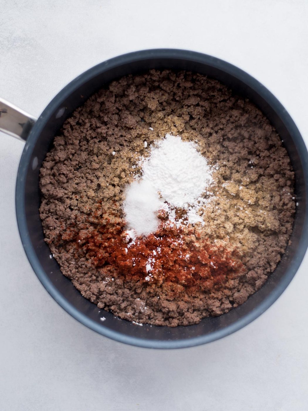 Seasonings added over cooked ground hamburger.
