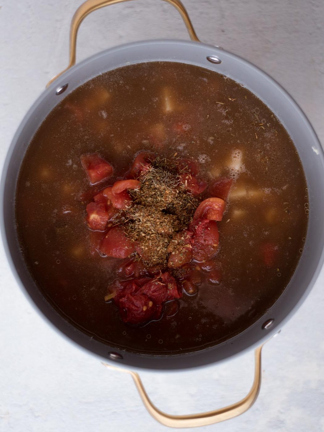 broth, potatoes, seasoning, ground beef, celery, and onion in a stock pot