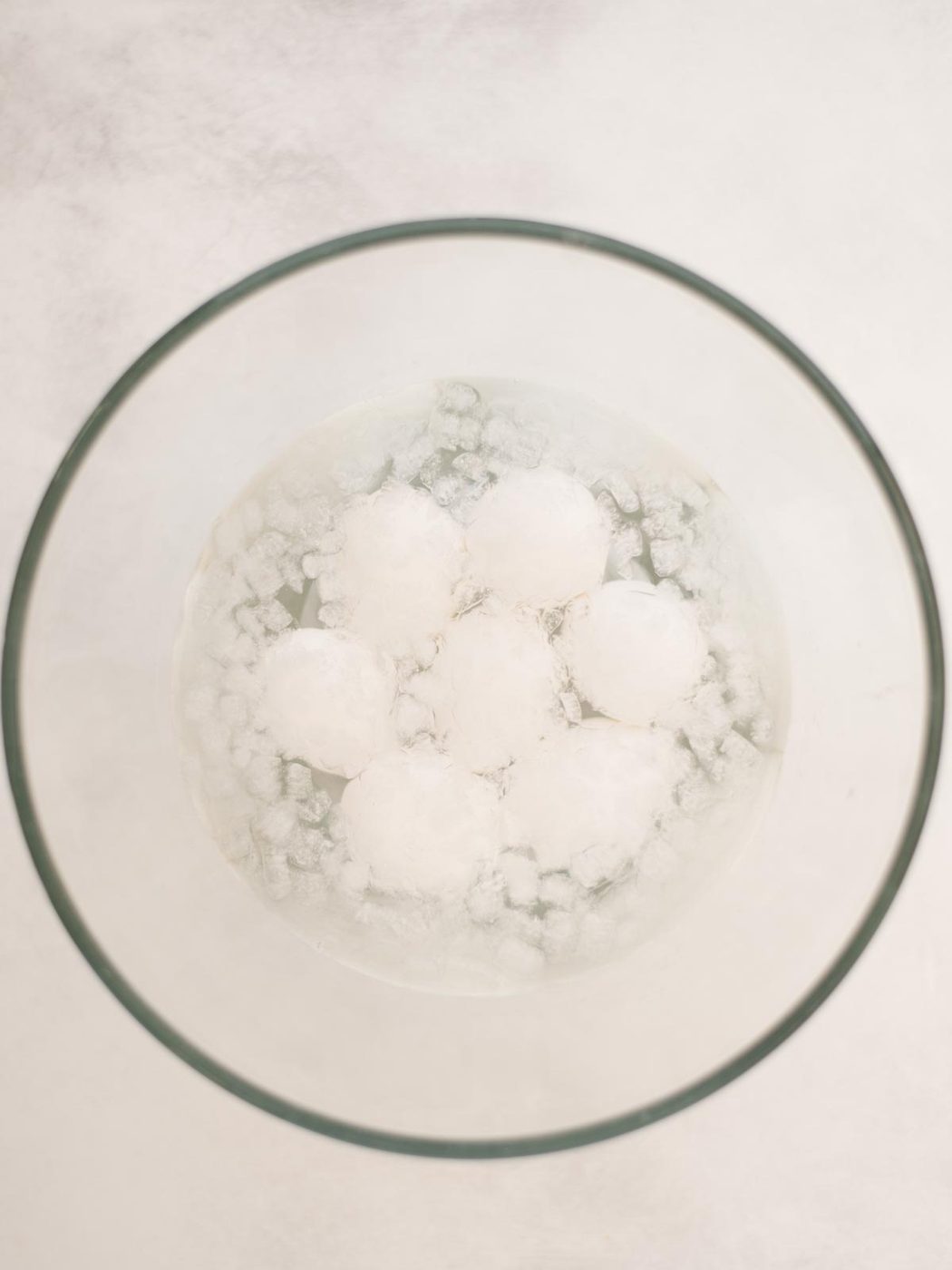 Hardboiled eggs in their shell, sitting in ice water.