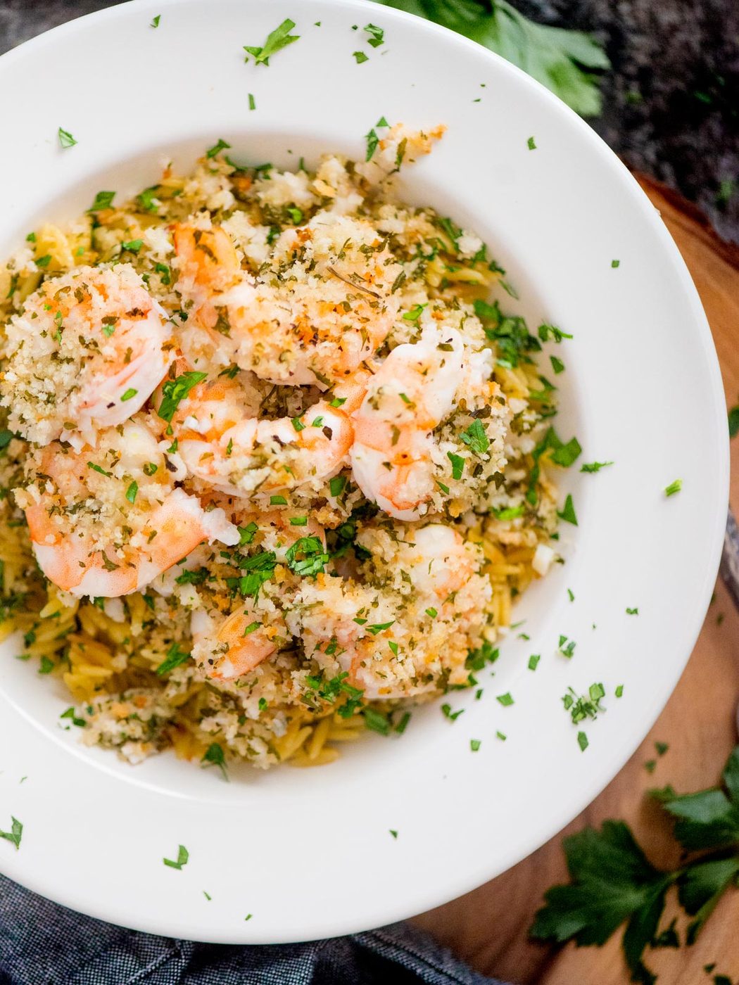 baked shrimp scampi served over orzo pasta and garnished with fresh parsley