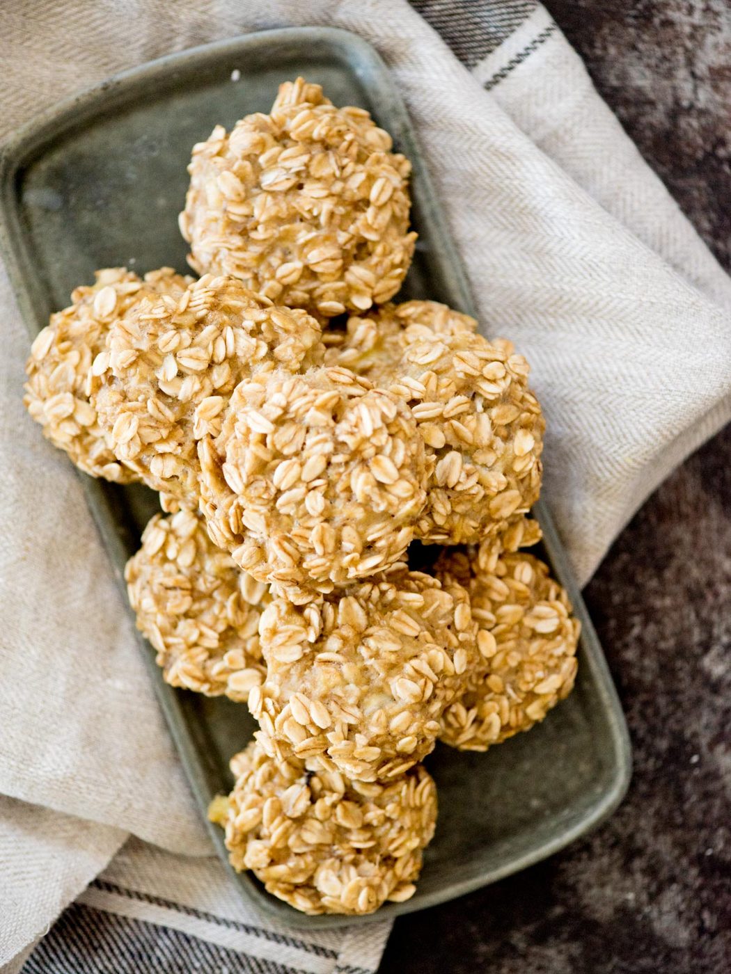 healthy banana oatmeal cookies stacked on a plate with a linen napkin