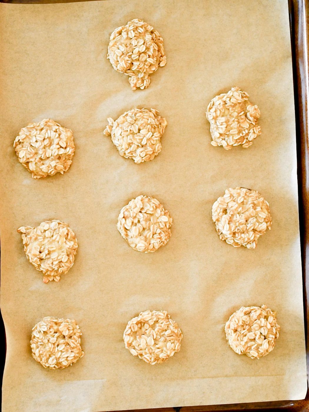 healthy banana oatmeal cookies on a parchment lined baking sheet