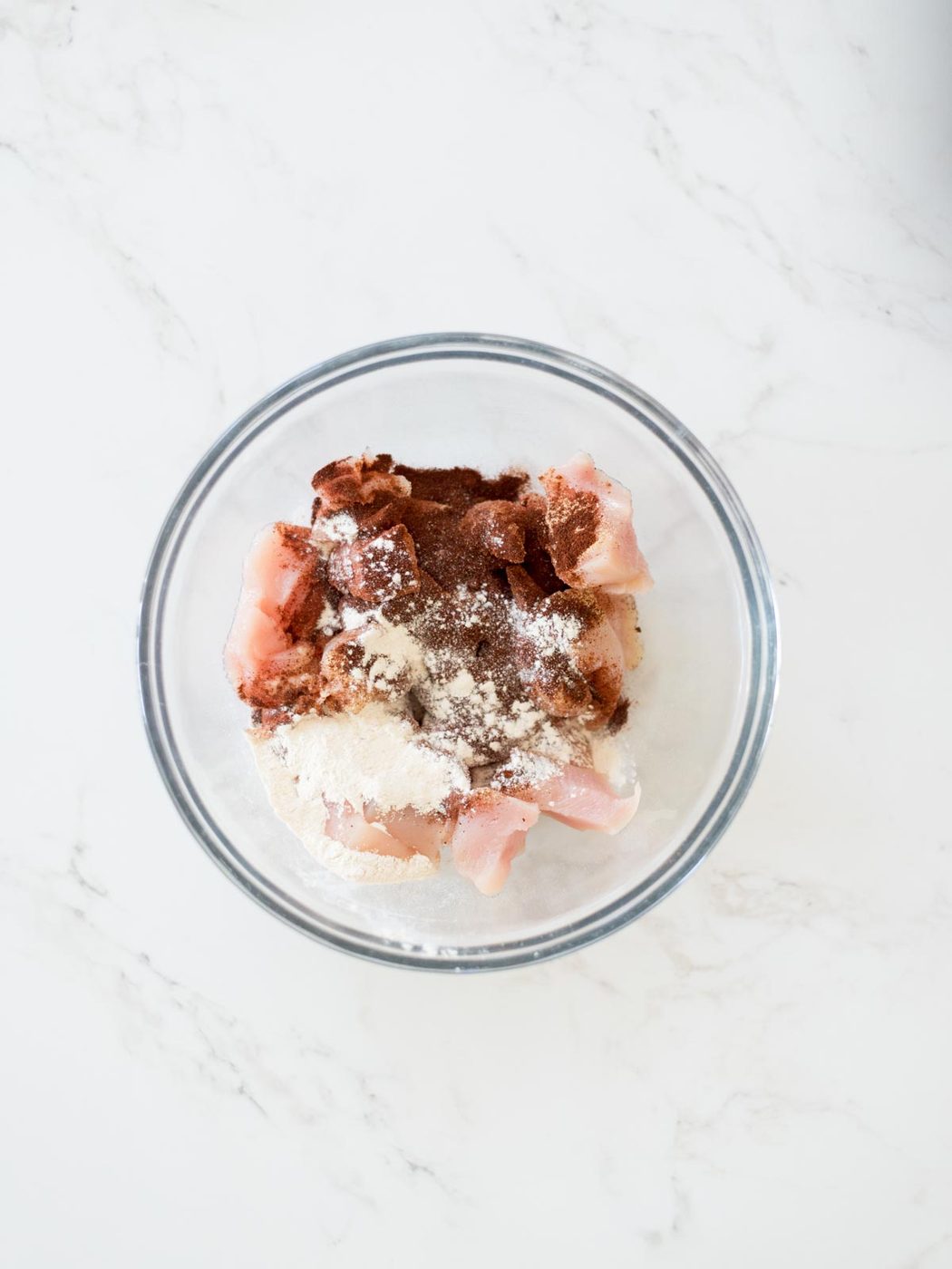 chicken and spices in a mixing bowl