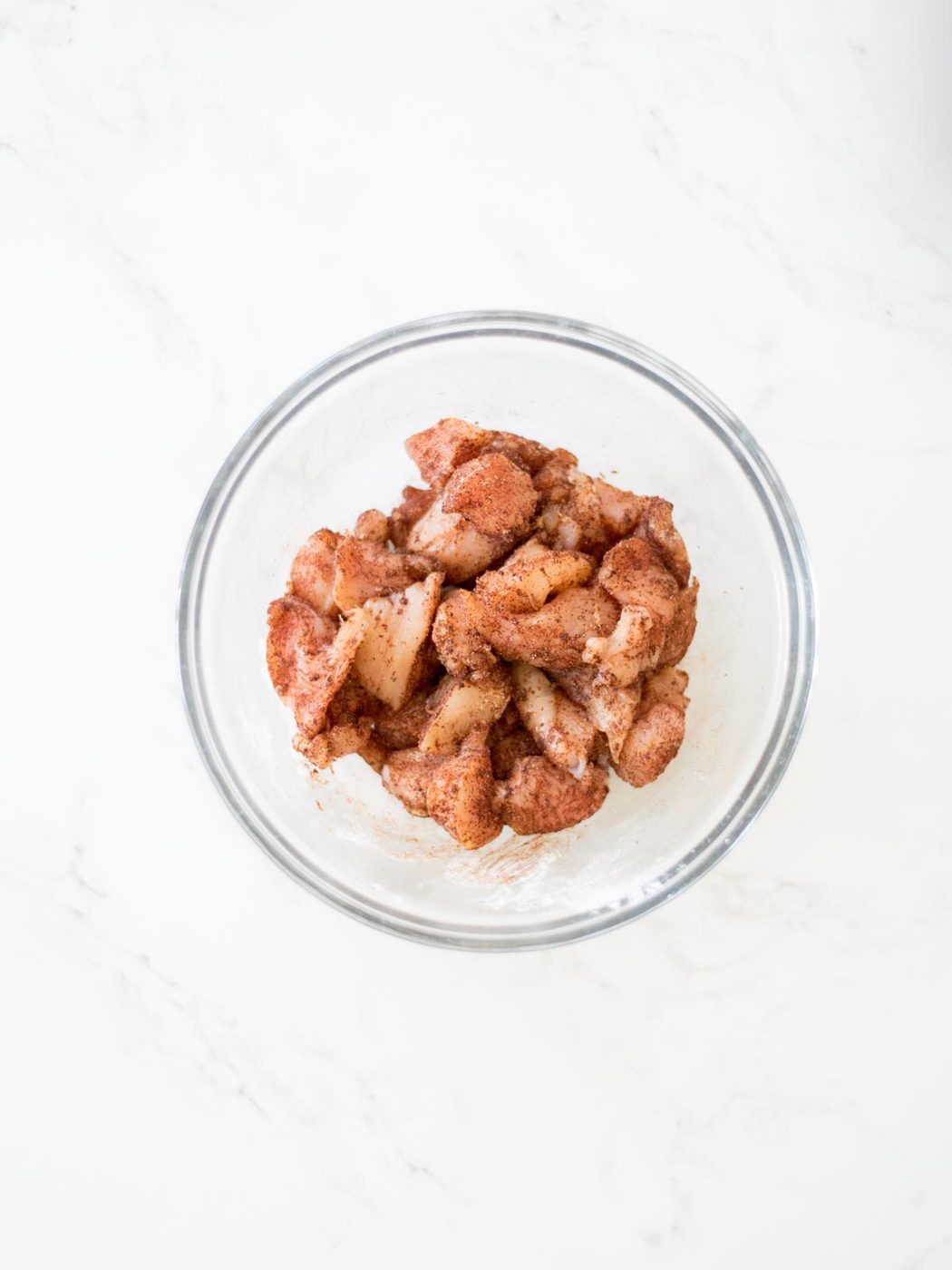 chicken and spices mixed together in a bowl