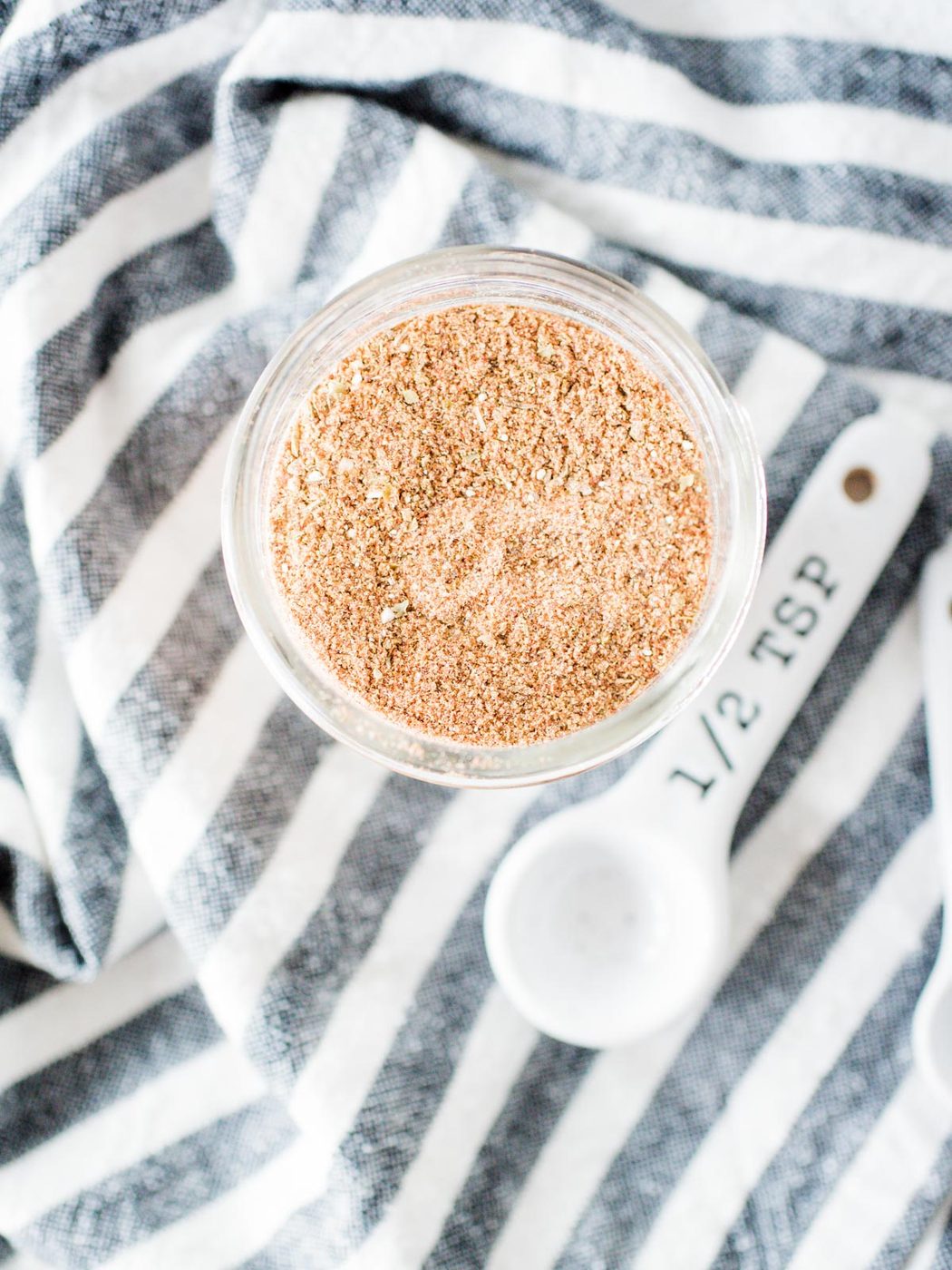 from-scratch taco seasoning in a jar on top of a striped cloth