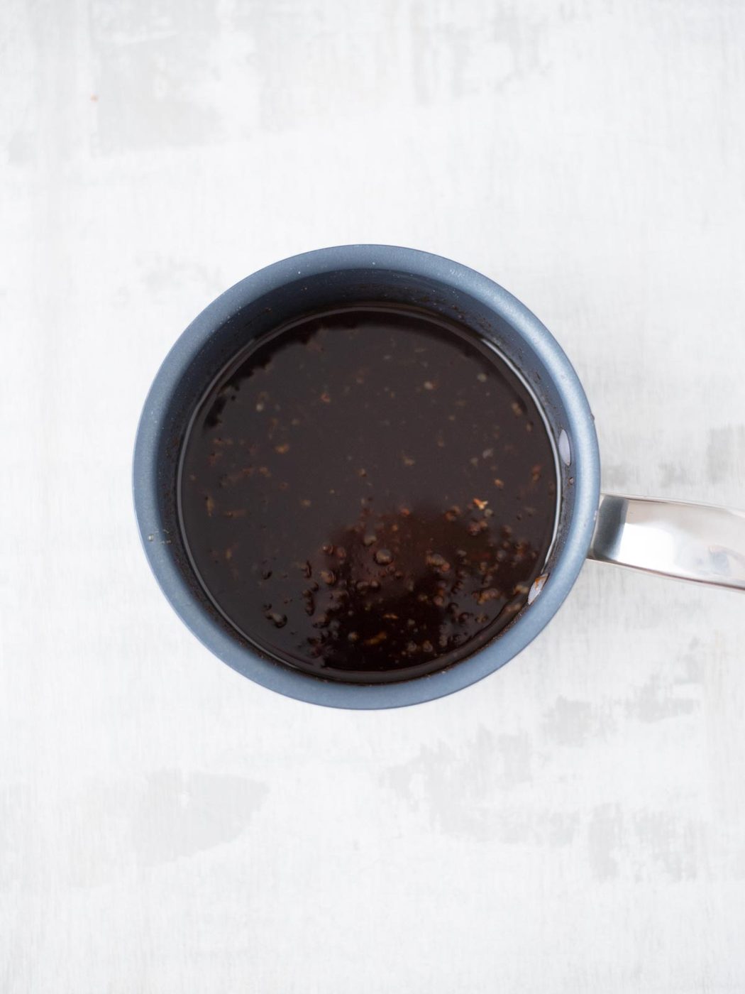 Small saucepan with honey sriracha sauce.