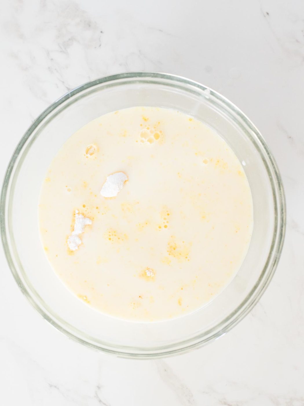 milk added to pudding mix in a mixing bowl