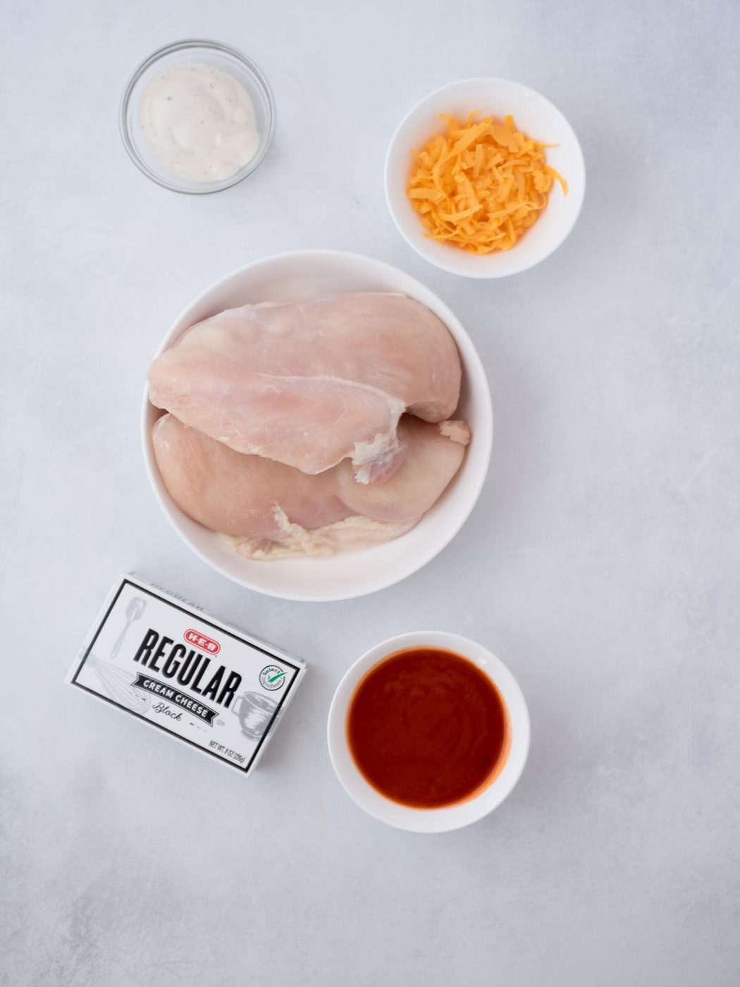 Ingredients shown are used to prepare Instant Pot Buffalo Chicken Dip.