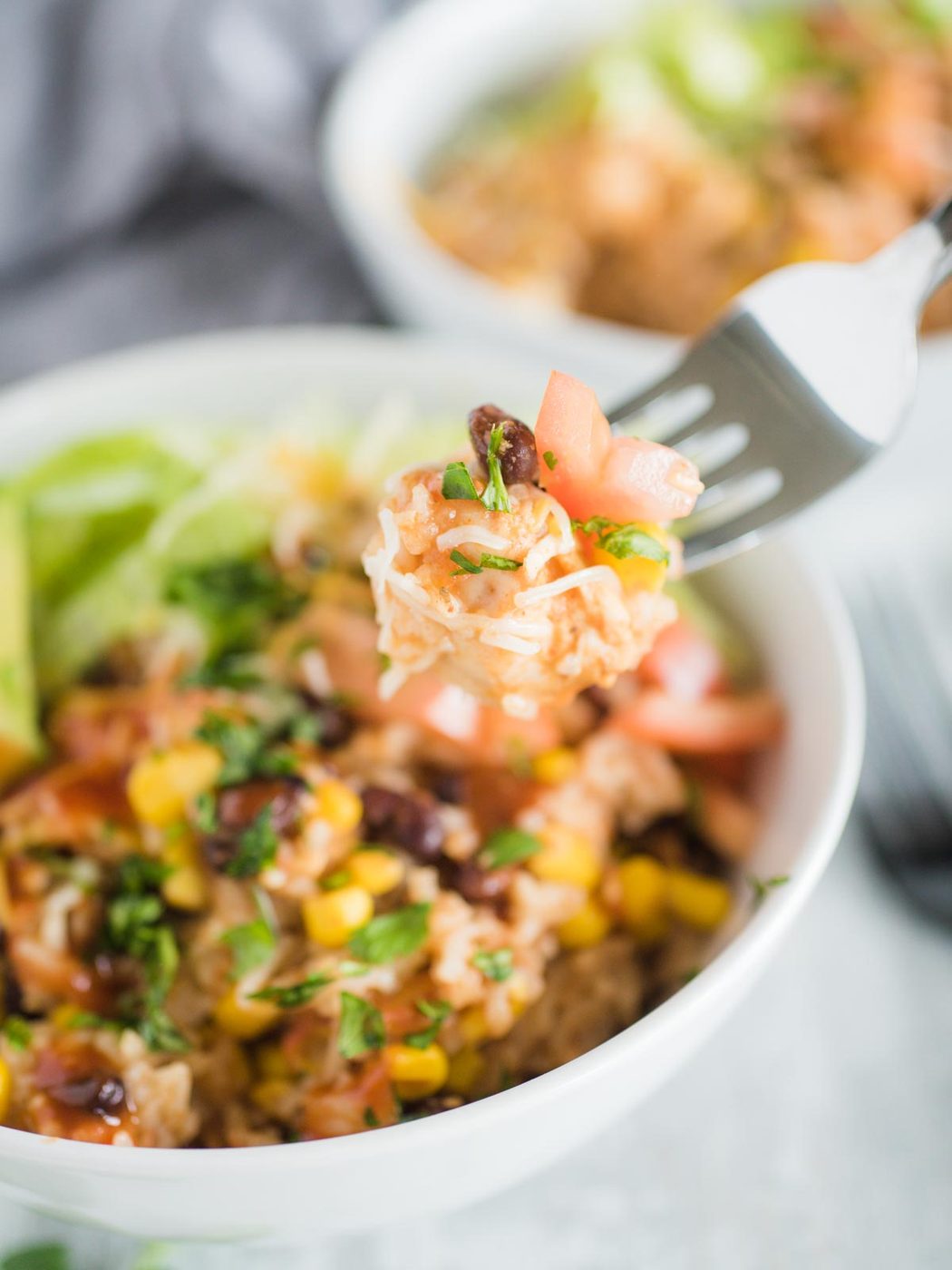 a fork with a bite of the burrito bowl on it