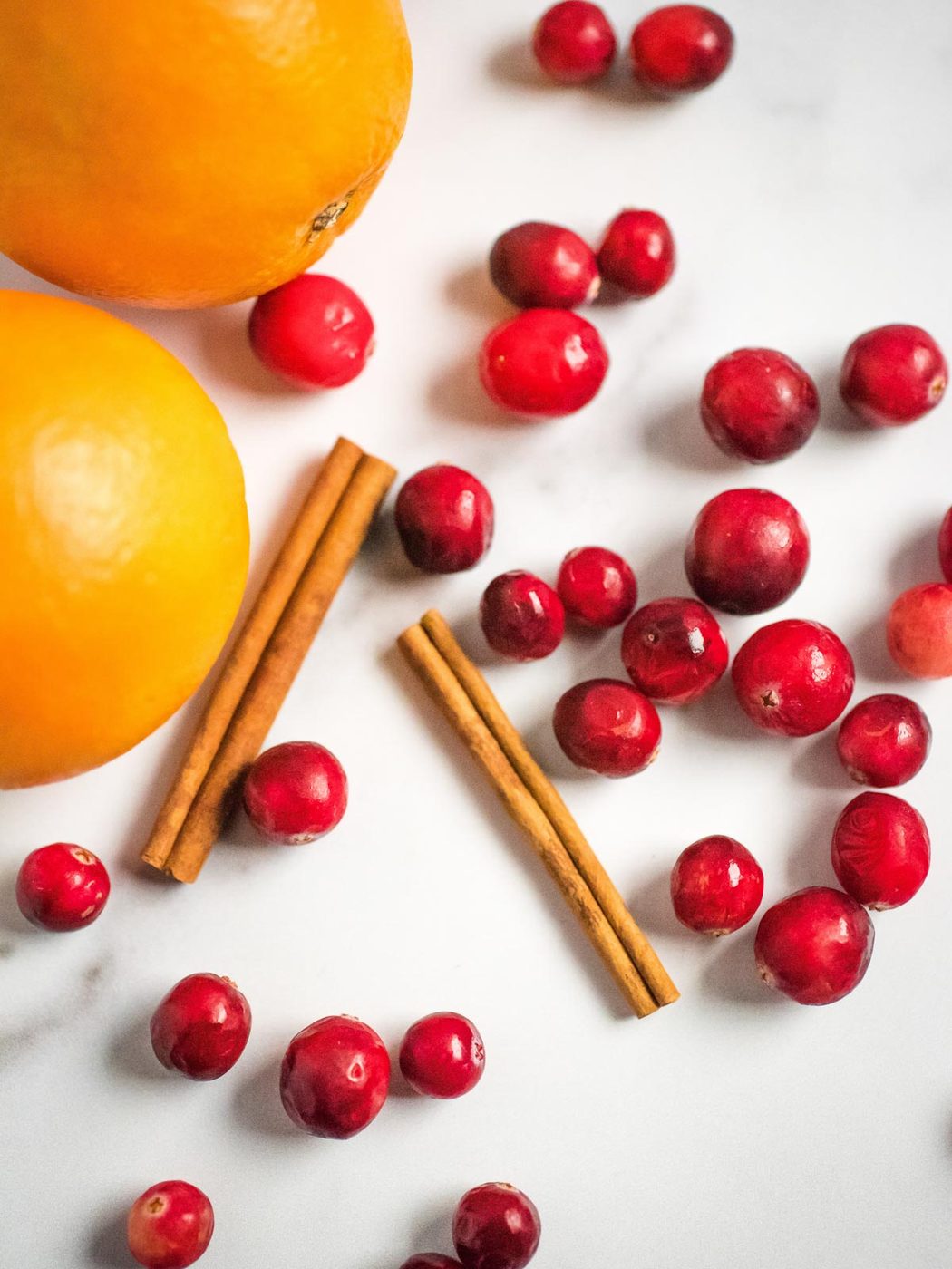 oranges cinnamon sticks and cranberries on the surface