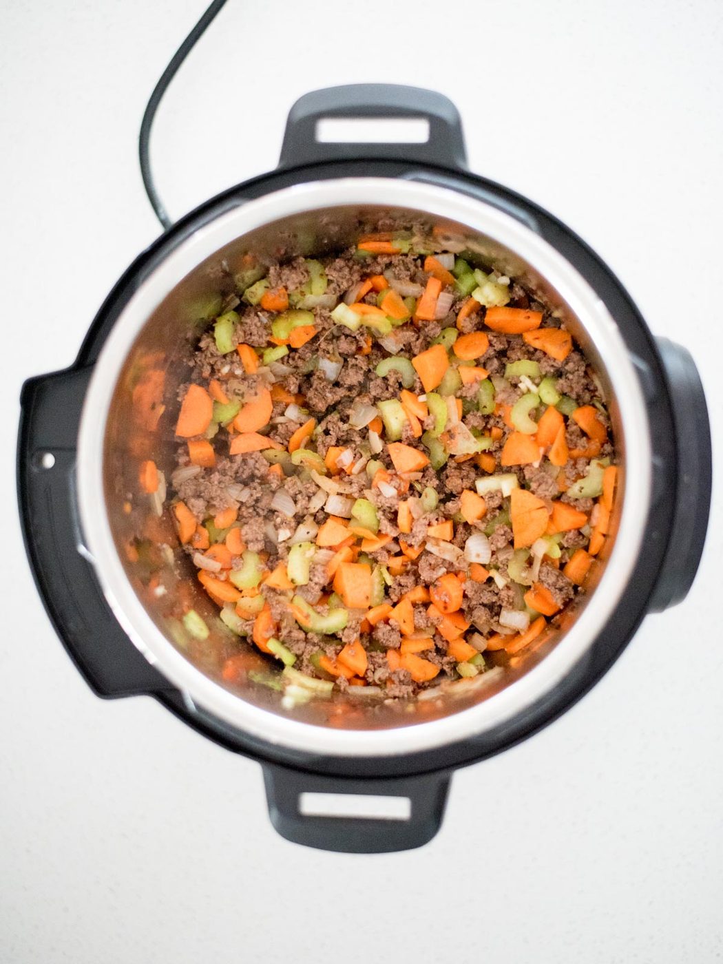how to cook instant pot spaghetti by sautéing vegetables and meat together