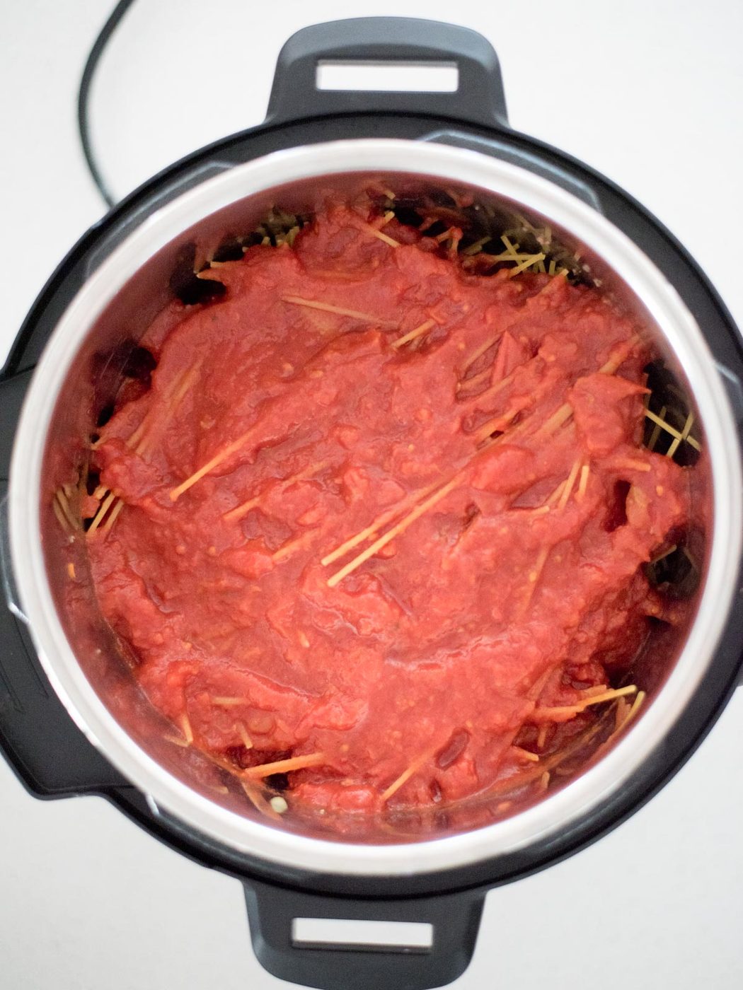 marinara sauce added on top of spaghetti pasta in the instant pot