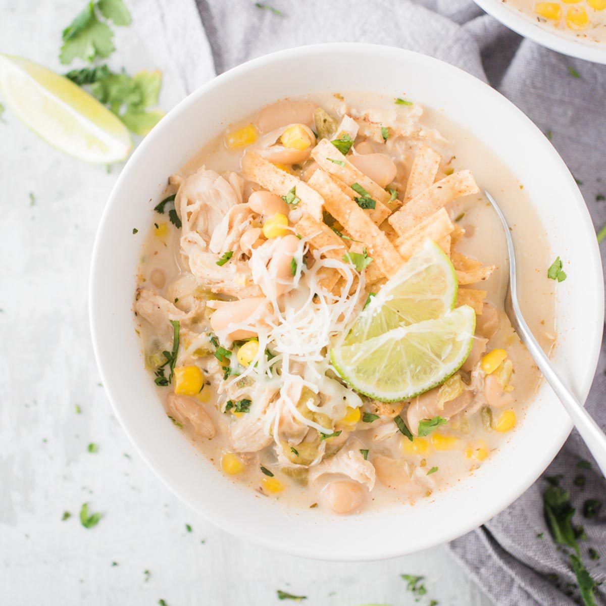 white chicken chili in a white bowl with a spoon