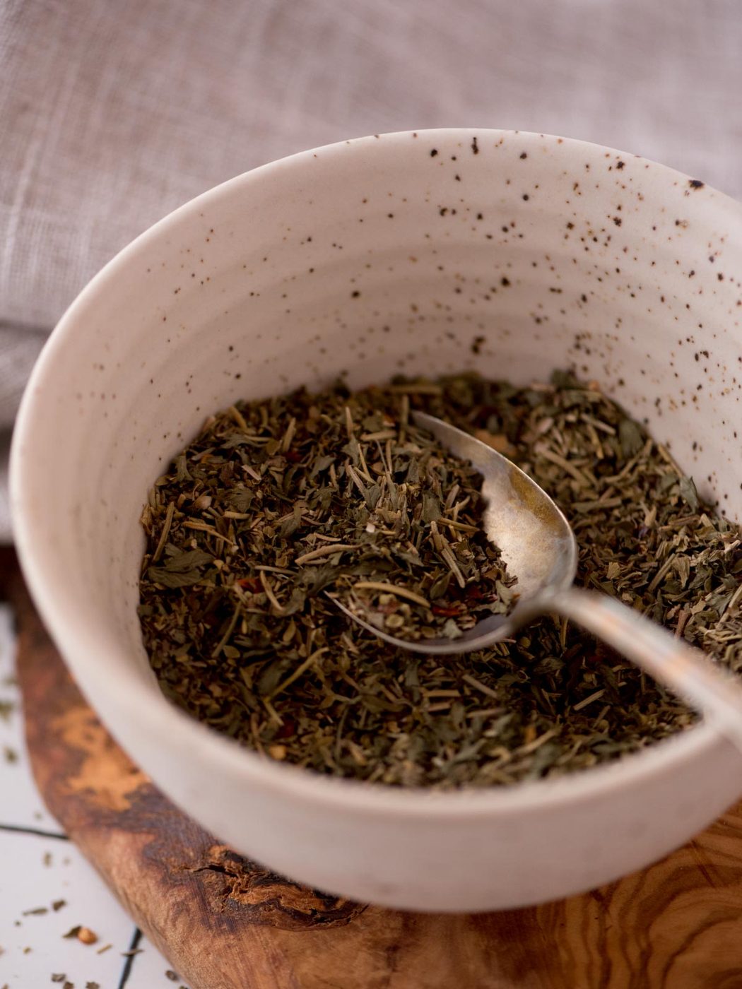 Spoon of from-scratch italian seasoning in a bowl.
