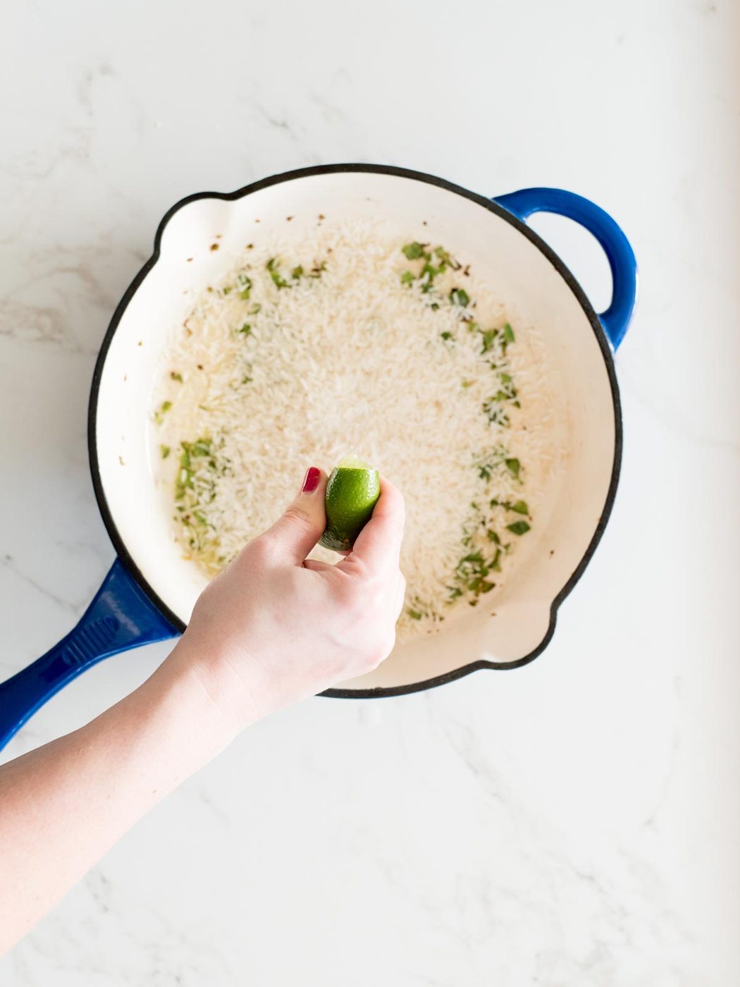 lime juice being squeezed into cast iron skillet