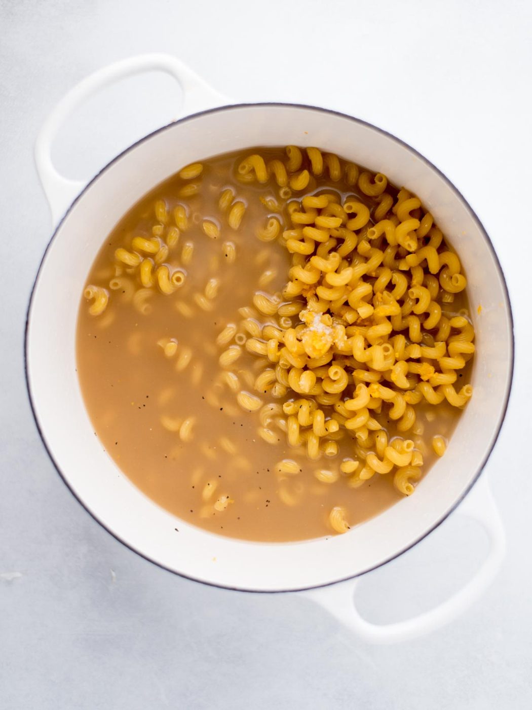 Dutch oven filled with uncooked pasta, lemon juice, seasonings and broth.