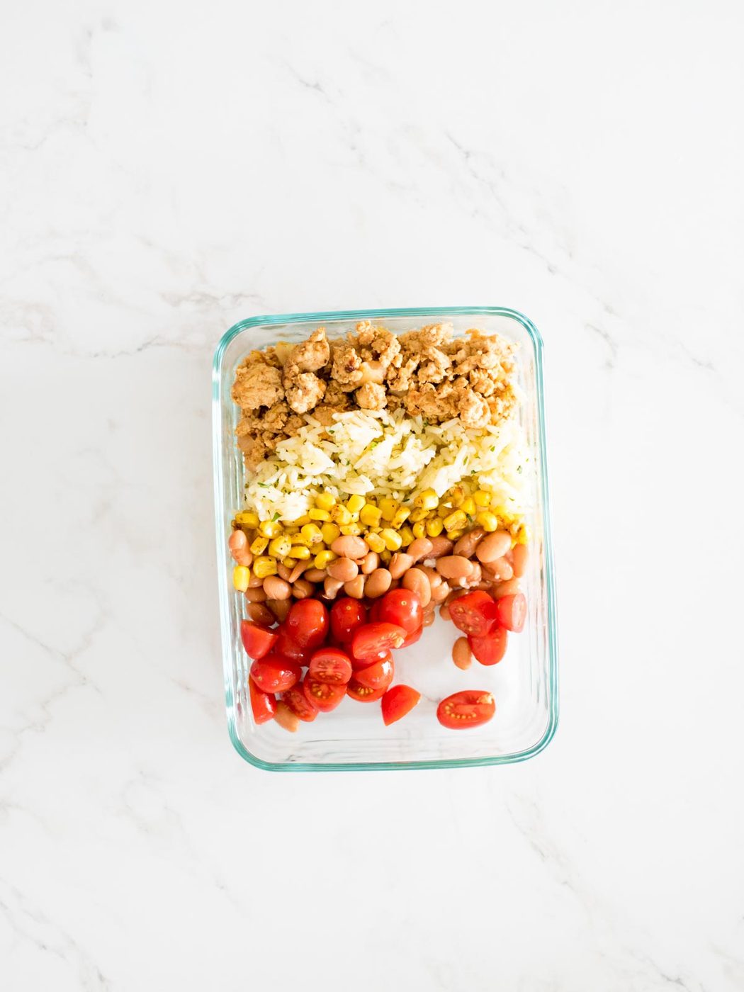 turkey, rice, corn, beans, and tomatoes added to a glass container