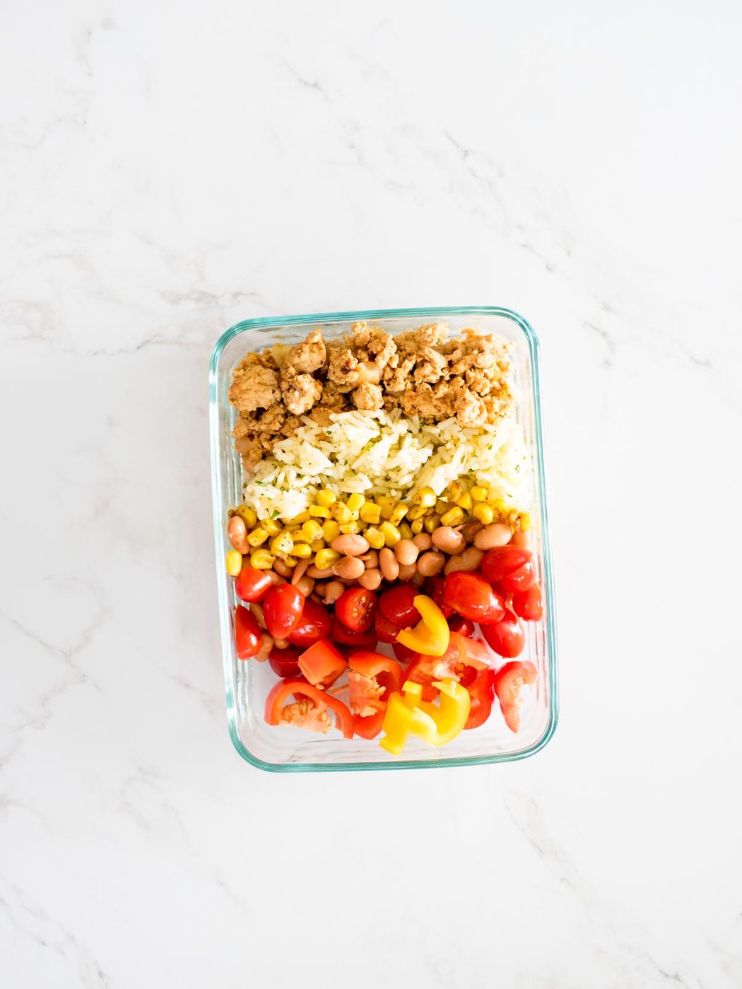 turkey, rice, corn, beans, tomatoes, and peppers added to a glass container