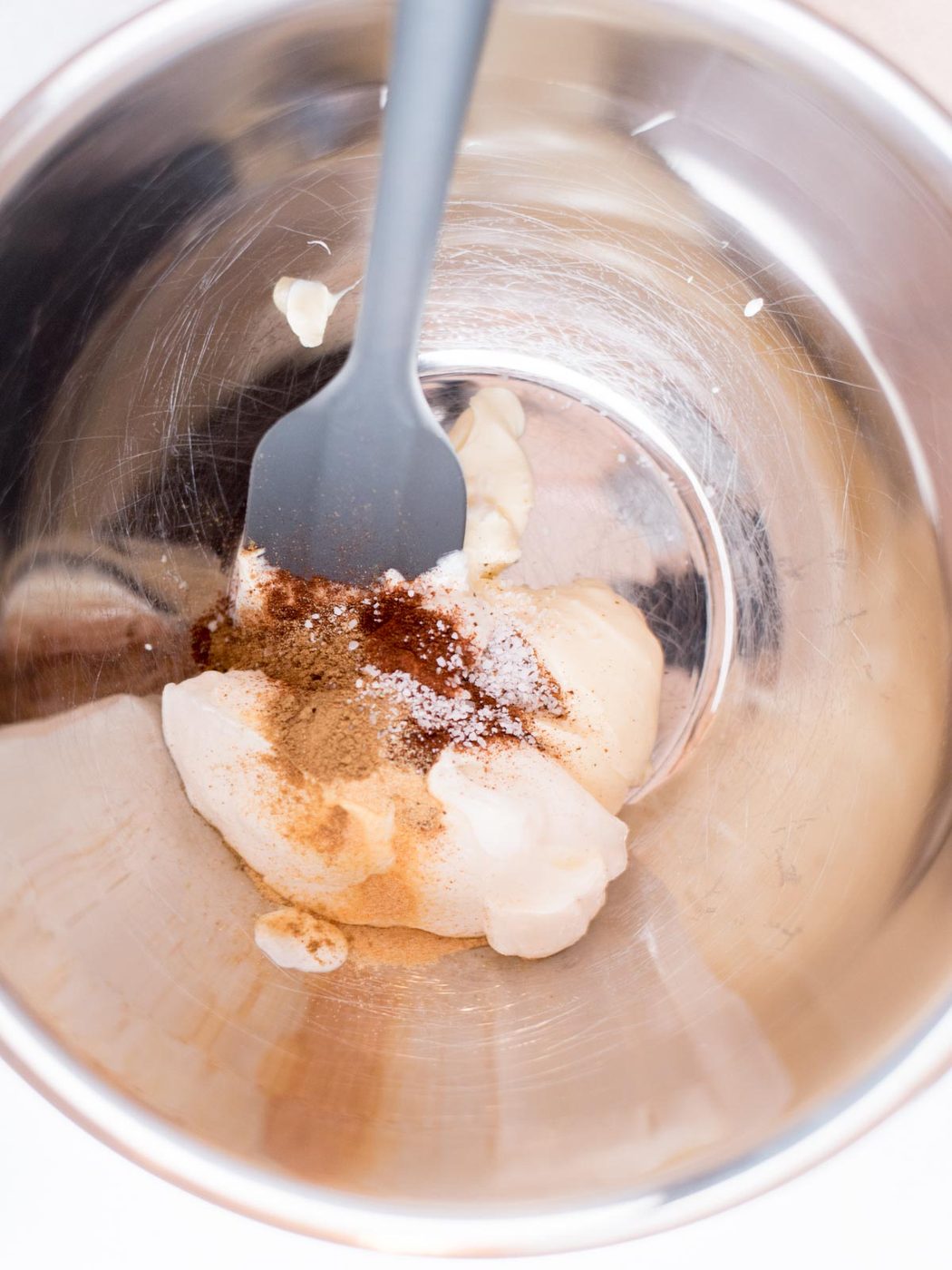 Seasonings measured into a mixing bowl with mayo and sour cream.
