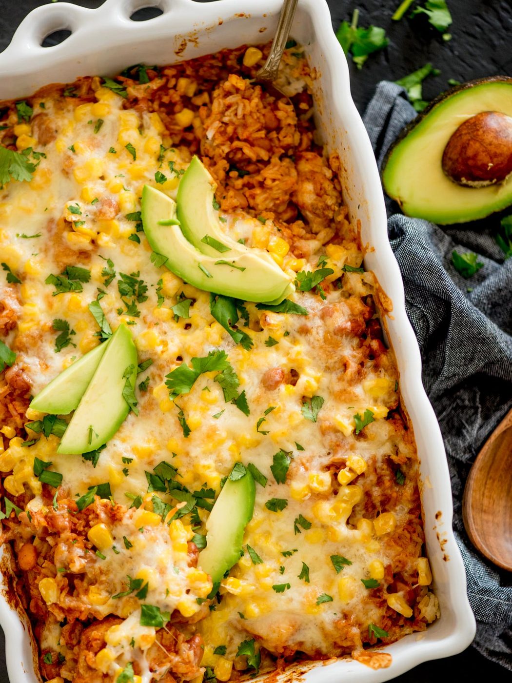 mexican rice casserole topped with cilantro and avocado