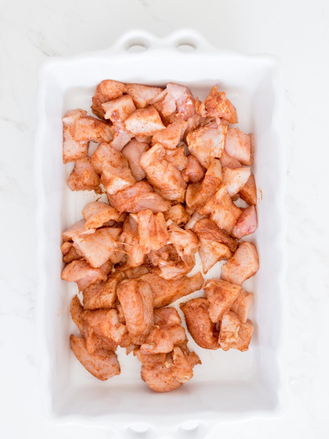 chicken mixed with taco seasoning in baking dish